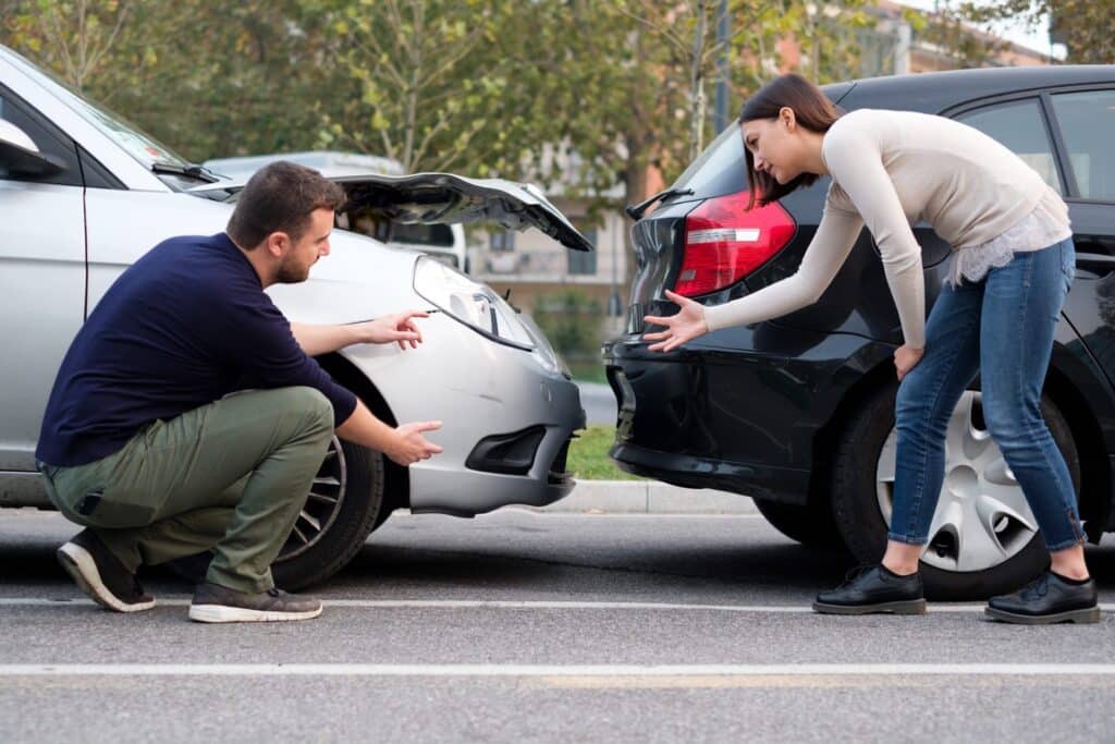 Man and woman arguing after an car accident