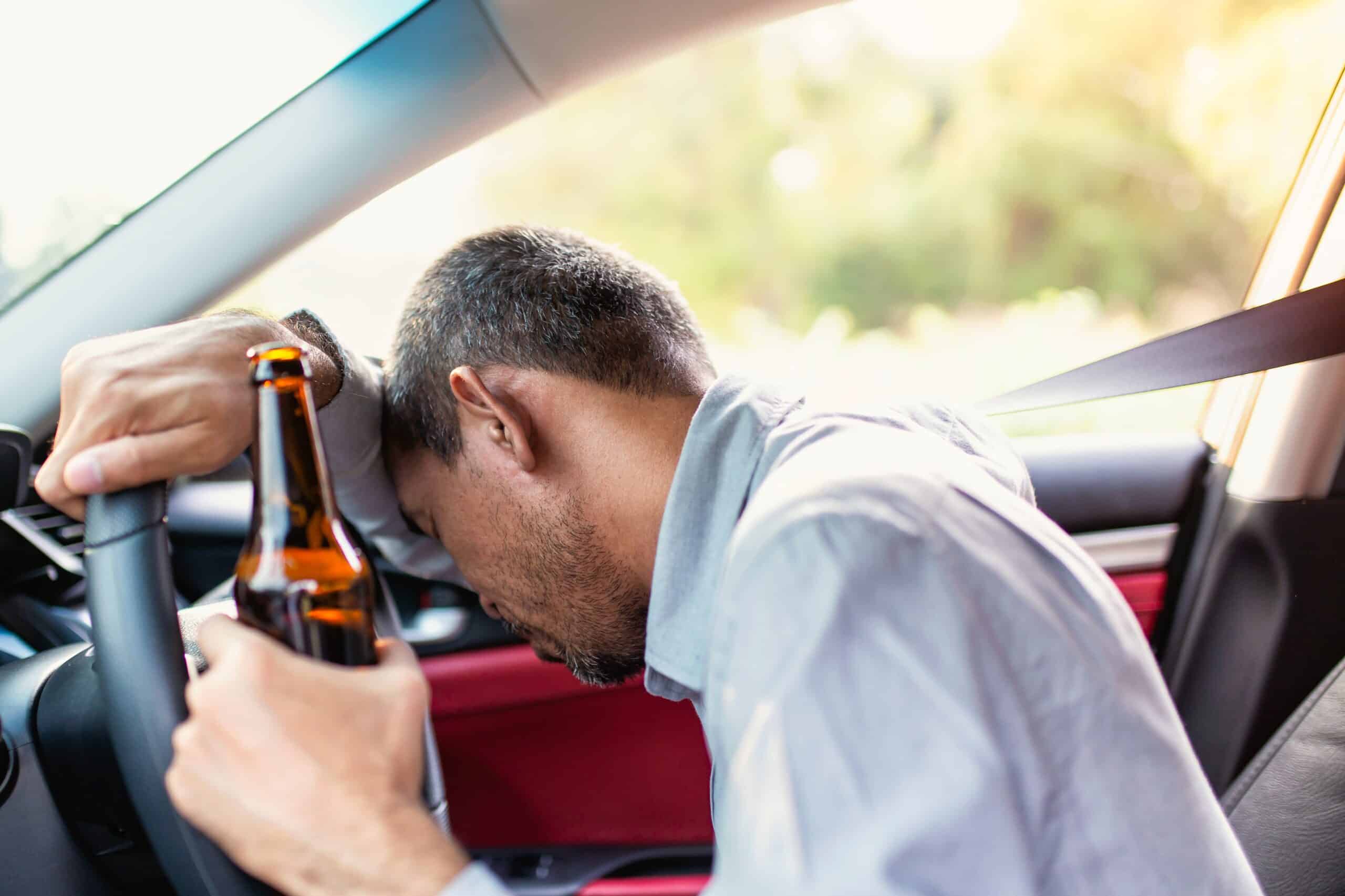 Person Sleeping By The Wheel While Holding A Beer